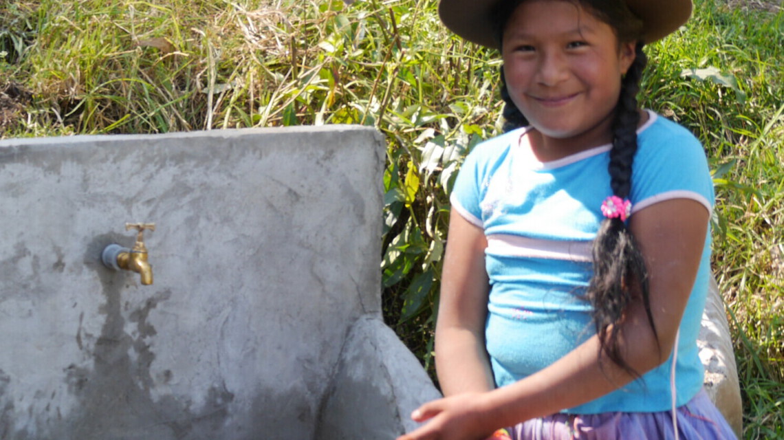 Ein Mädchen aus Peru steht an einer Wasserstelle
